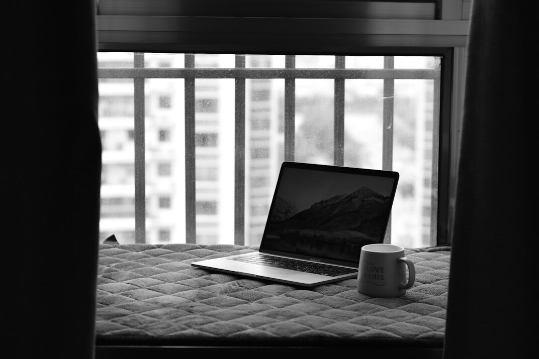 Hands typing on a laptop with analytics charts on screen