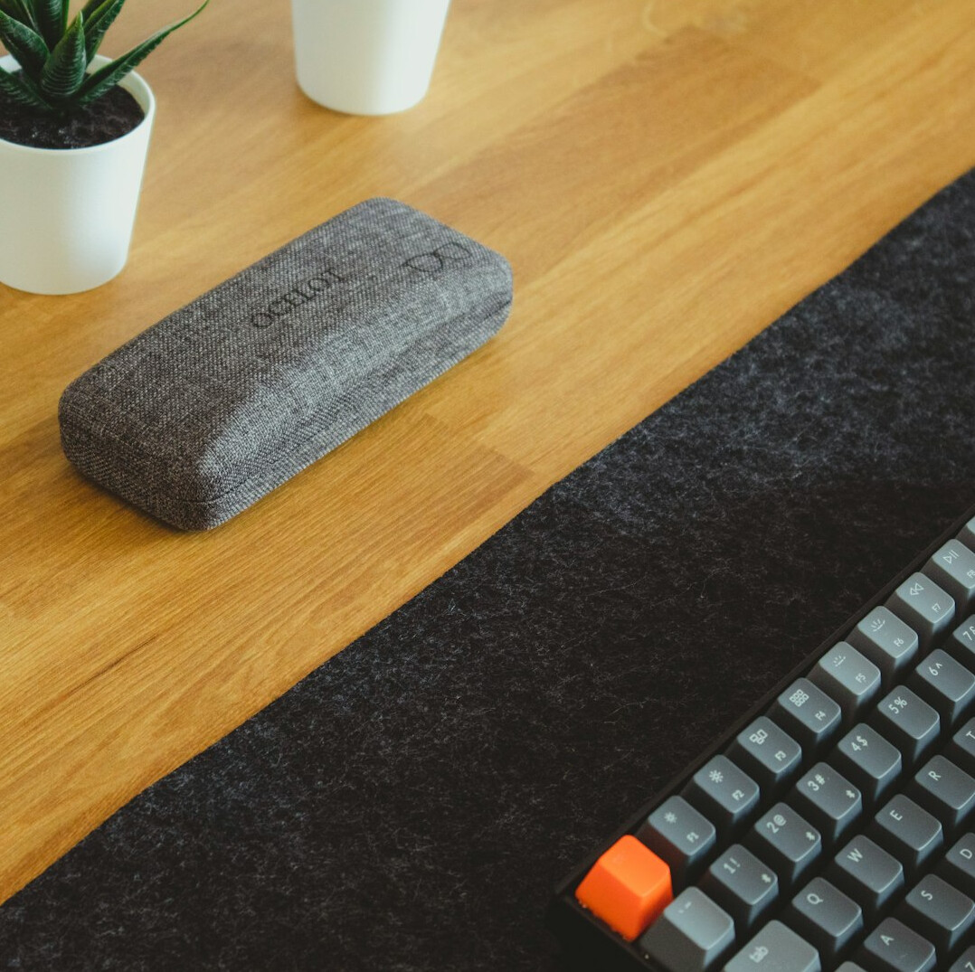 Tidy office desk with notebook, pen and plant